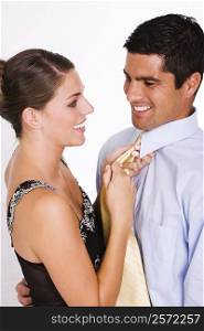 Side profile of a young woman adjusting a mid adult man&acute;s tie
