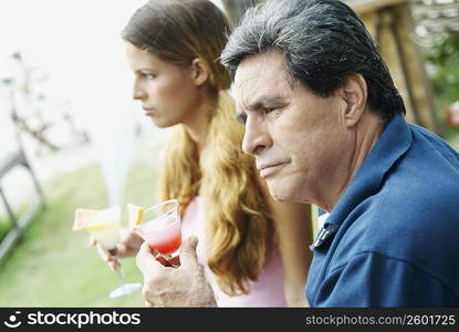 Side profile of a young woman and a mature man holding glasses