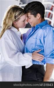 Side profile of a young woman and a mid adult man embracing each other