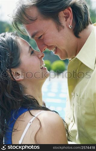 Side profile of a young woman and a mid adult man looking at each other and smiling