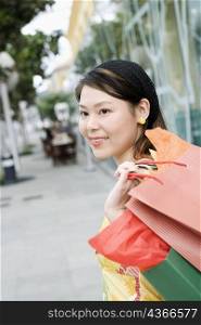 Side profile of a young woman carrying shopping bags
