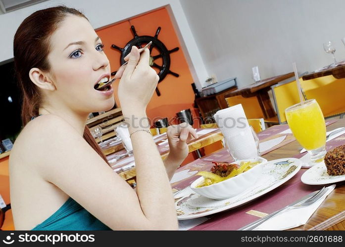 Side profile of a young woman eating