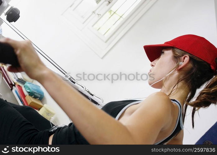 Side profile of a young woman exercising in a gym