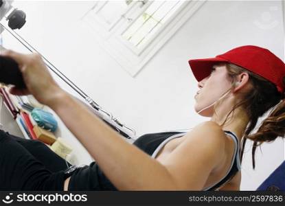 Side profile of a young woman exercising in a gym