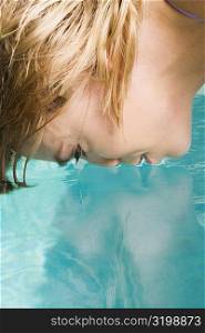 Side profile of a young woman face down in a swimming pool