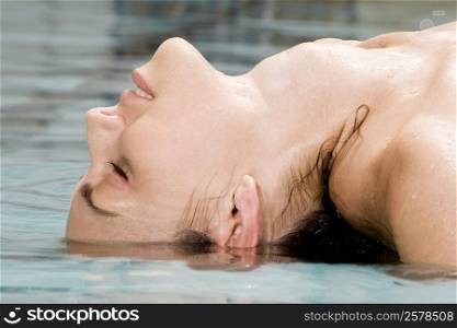 Side profile of a young woman floating on water