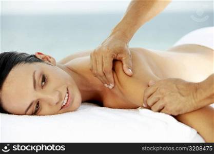 Side profile of a young woman getting a back massage