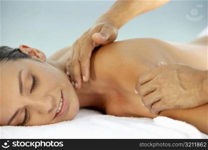 Side profile of a young woman getting a back massage