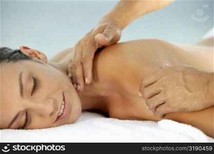 Side profile of a young woman getting a shoulder massage