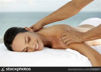 Side profile of a young woman getting a shoulder massage