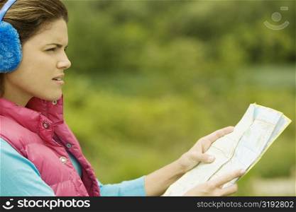 Side profile of a young woman holding a map