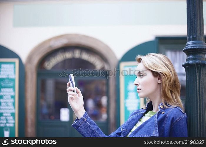 Side profile of a young woman holding a mobile phone