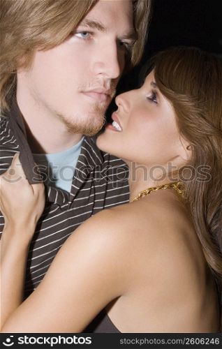 Side profile of a young woman holding the collar of a young man