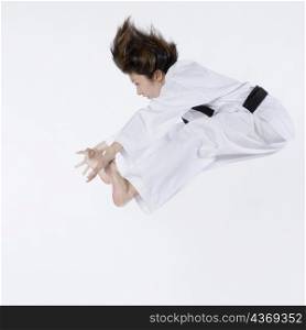 Side profile of a young woman jumping and practicing martial arts