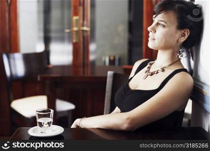 Side profile of a young woman leaning against a wall and thinking