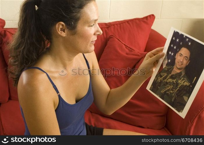 Side profile of a young woman looking at a photograph