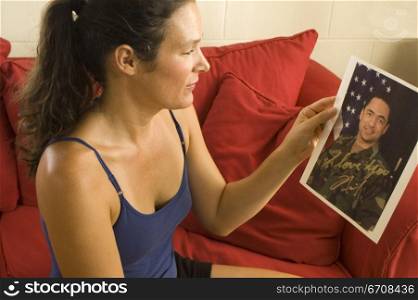 Side profile of a young woman looking at a photograph