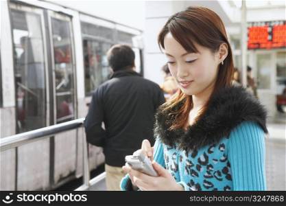 Side profile of a young woman operating a mobile phone with a digitized pen
