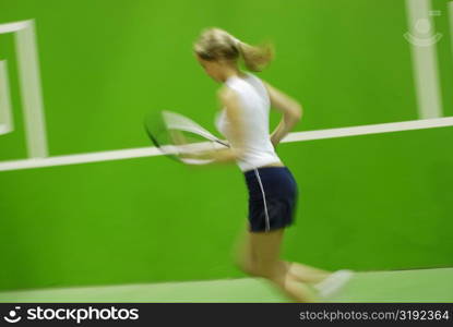 Side profile of a young woman playing tennis