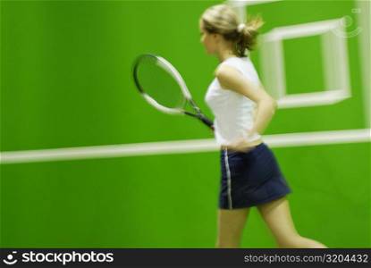 Side profile of a young woman playing tennis