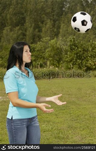 Side profile of a young woman playing with a soccer ball