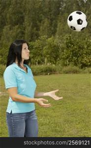 Side profile of a young woman playing with a soccer ball