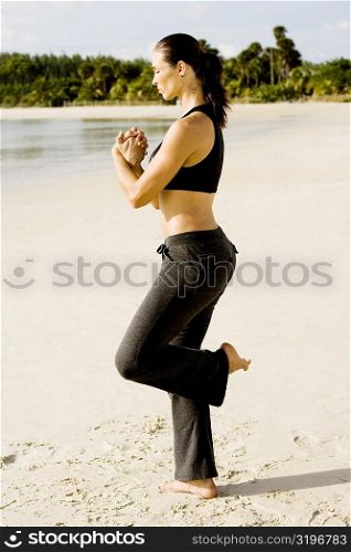 Side profile of a young woman practicing martial arts on the beach