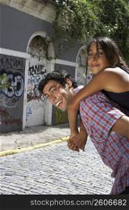 Side profile of a young woman riding piggyback on a young man, Puerto Rico