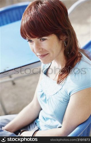 Side profile of a young woman sitting at a sidewalk cafe