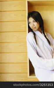 Side profile of a young woman sitting in a box on the wall