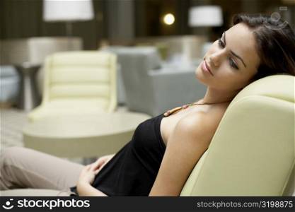 Side profile of a young woman sitting on a chair