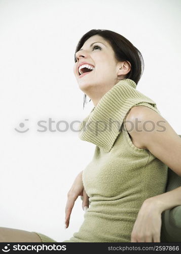 Side profile of a young woman sitting on a chair and smiling