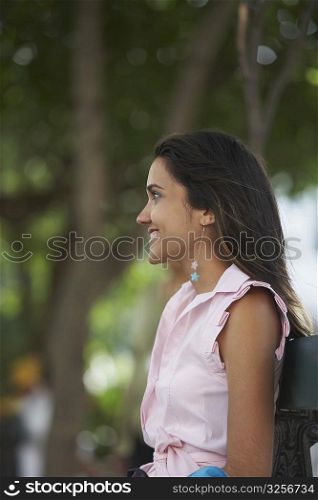 Side profile of a young woman smiling and looking away