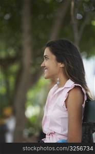 Side profile of a young woman smiling and looking away
