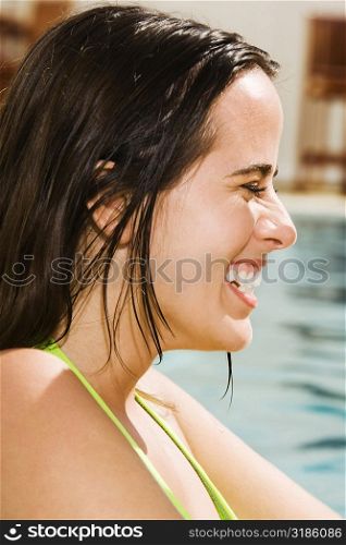 Side profile of a young woman smiling in a swimming pool