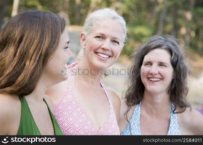 Side profile of a young woman smiling with two mature women