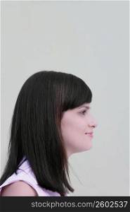 Side profile of a young woman smirking