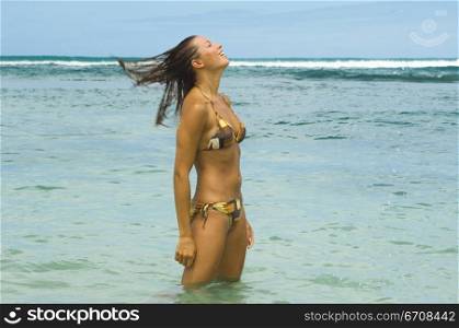 Side profile of a young woman standing in water