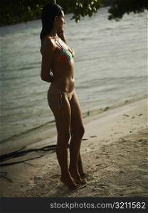 Side profile of a young woman standing on the beach
