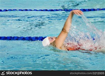 Side profile of a young woman swimming in a swimming pool