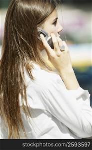Side profile of a young woman talking on a mobile phone