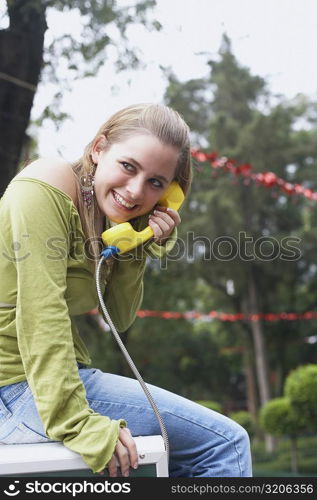 Side profile of a young woman talking on the telephone
