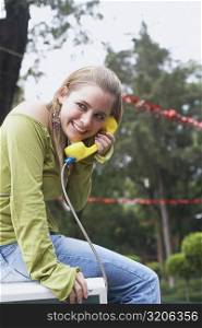 Side profile of a young woman talking on the telephone