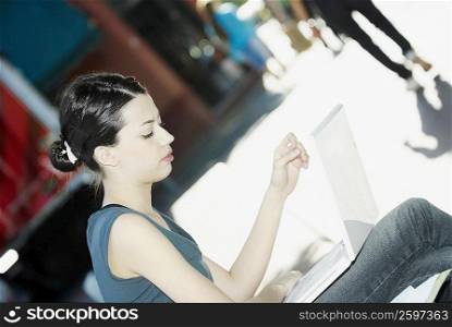 Side profile of a young woman using a laptop