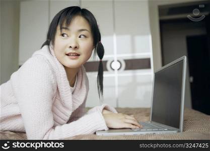 Side profile of a young woman using a laptop