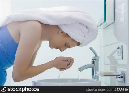 Side profile of a young woman washing her face