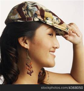 Side profile of a young woman wearing a cap and smiling
