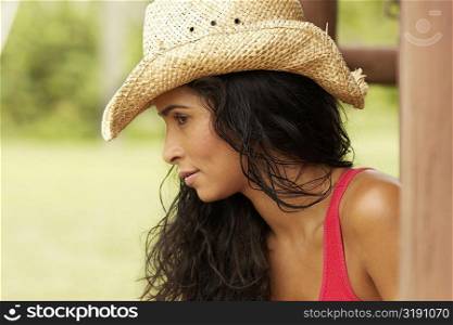 Side profile of a young woman wearing a cowboy hat