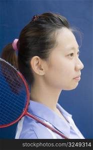Side profile of a young woman with a badminton racket