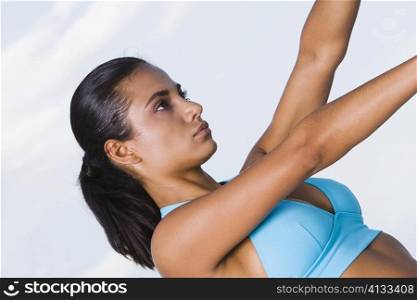 Side profile of a young woman with her arm outstretched